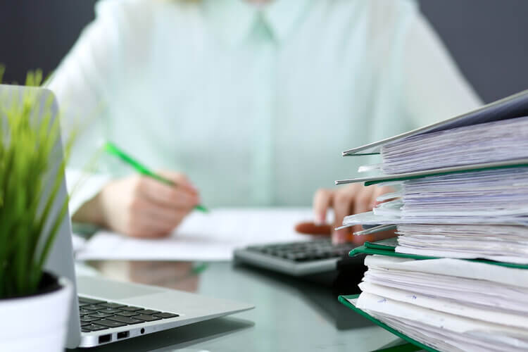 Close up of female accountants 's calculating at her desk